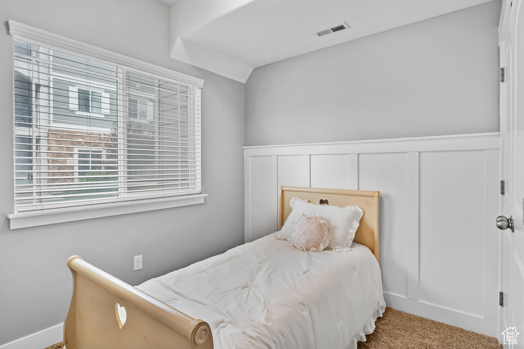 Bedroom with wainscoting, carpet flooring, a decorative wall, and visible vents