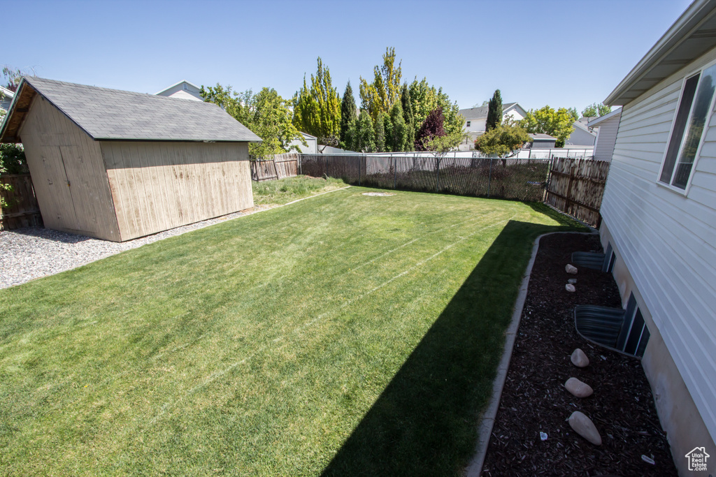 View of yard featuring an outbuilding, a shed, and a fenced backyard