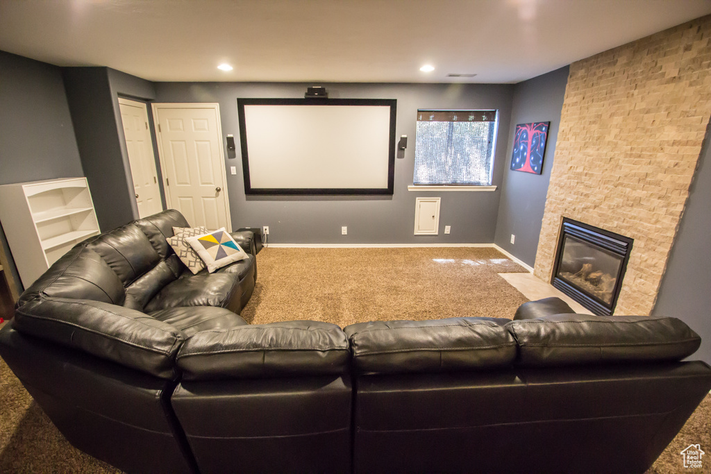 Home theater featuring recessed lighting, baseboards, a fireplace with flush hearth, and carpet floors