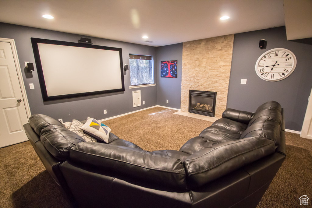 Home theater featuring recessed lighting, baseboards, a stone fireplace, and carpet floors