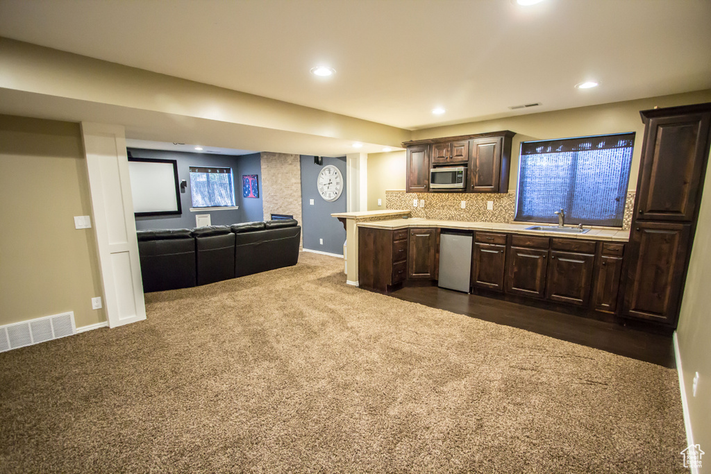 Kitchen with a sink, visible vents, dark brown cabinetry, light countertops, and appliances with stainless steel finishes