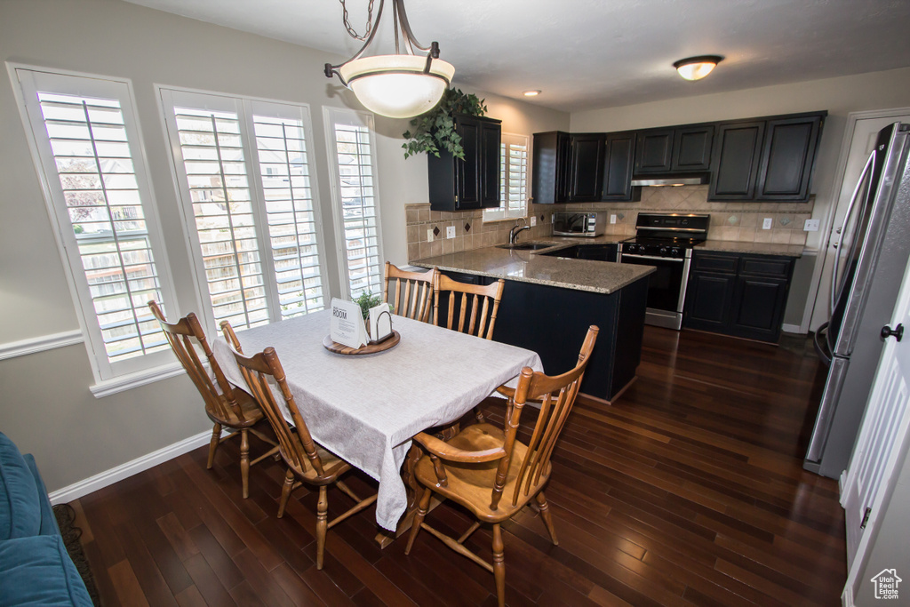 Dining area featuring baseboards and dark wood-style floors