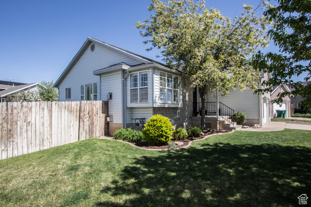 View of front of property with a front yard and fence