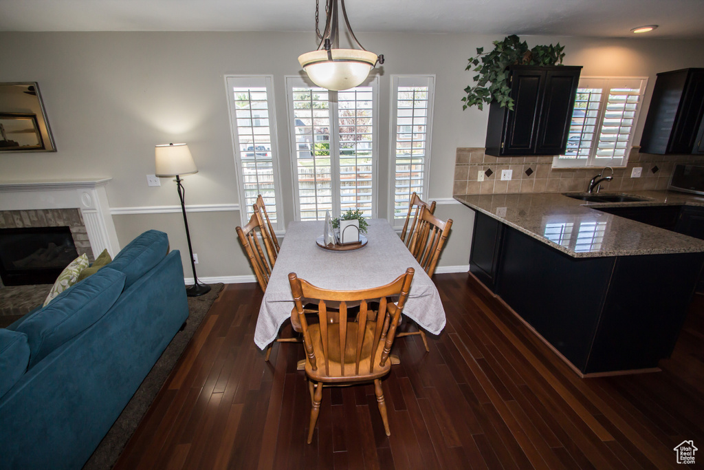 Dining space with baseboards, dark wood-style flooring, and a fireplace