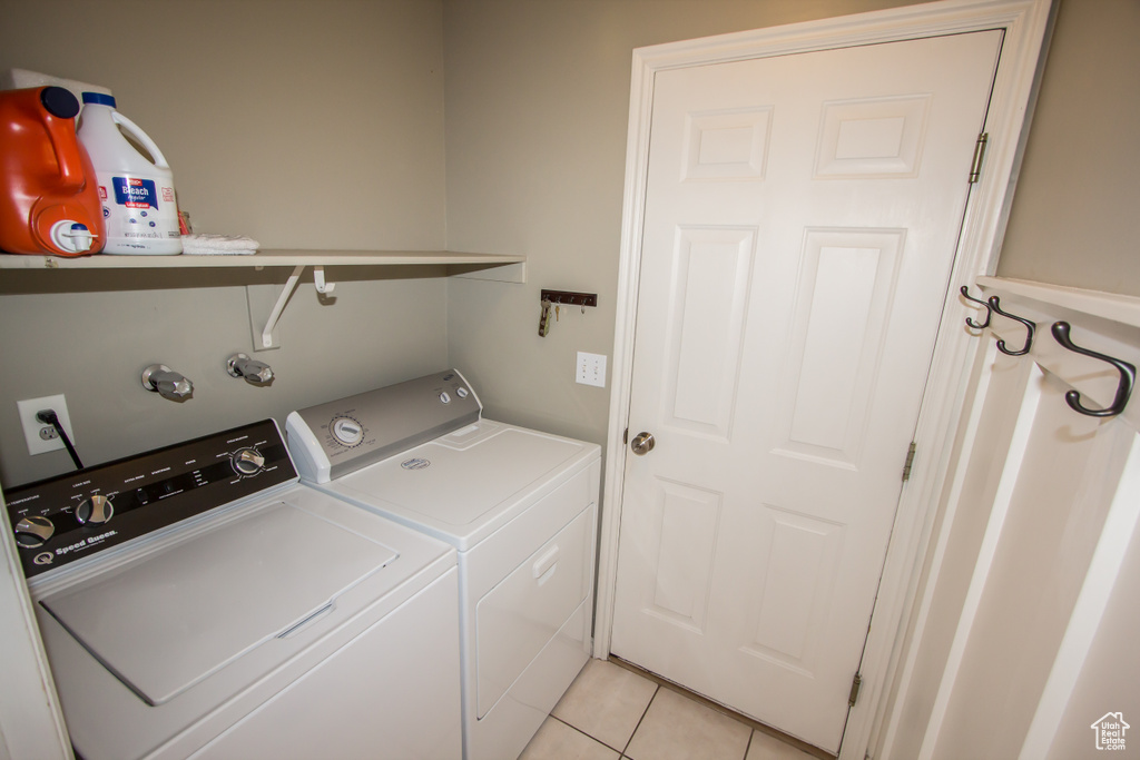 Clothes washing area featuring laundry area, light tile patterned flooring, and independent washer and dryer