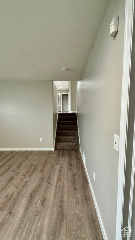 Stairway featuring wood finished floors and baseboards