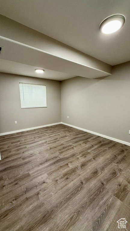 Finished basement with baseboards and wood finished floors