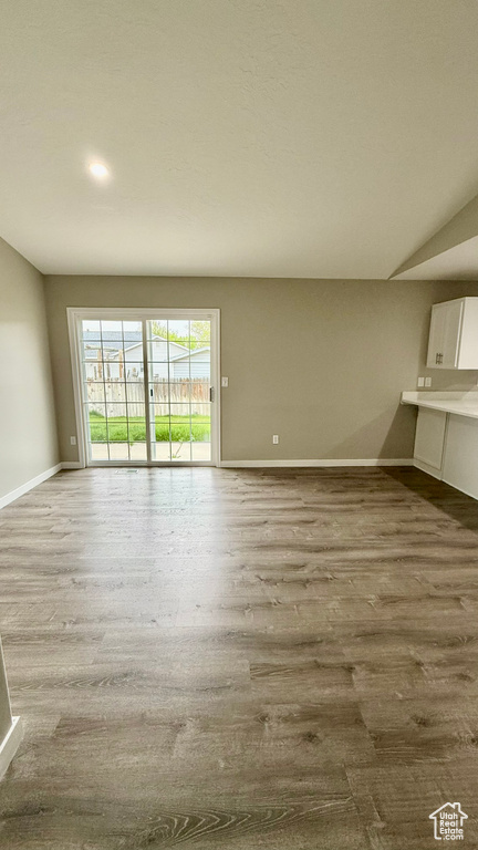 Unfurnished living room with baseboards and wood finished floors