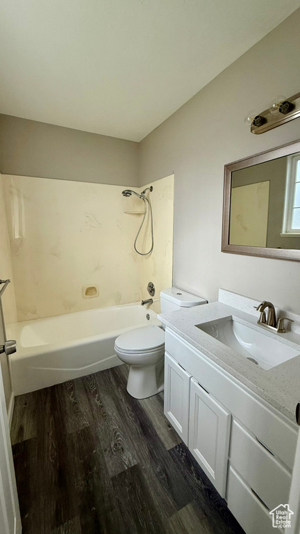 Bathroom featuring wood finished floors, toilet,  shower combination, and vanity
