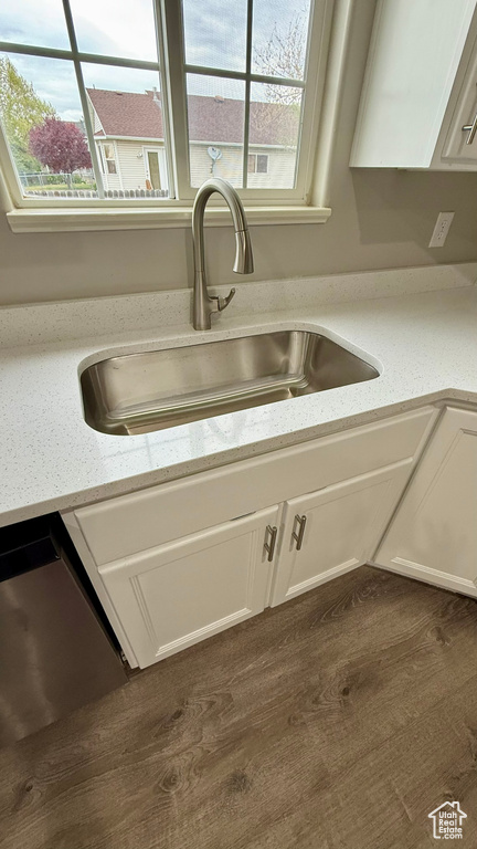 Kitchen view of a sink, white cabinetry, and dishwasher