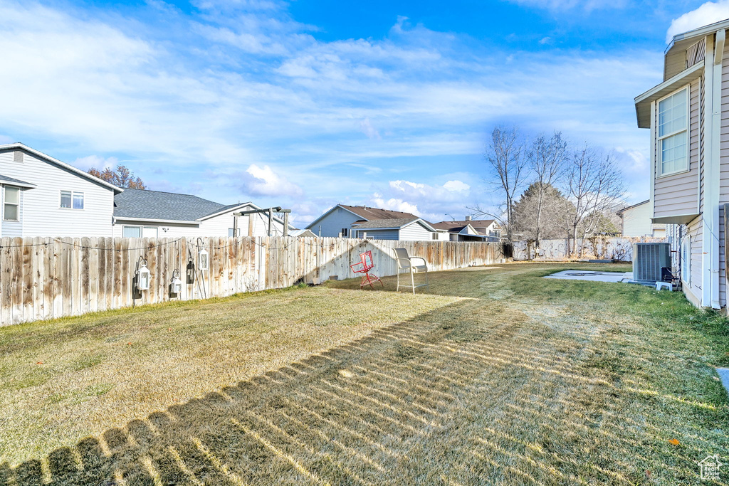 View of yard featuring a residential view and central AC unit