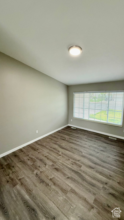 Spare room with baseboards and wood finished floors