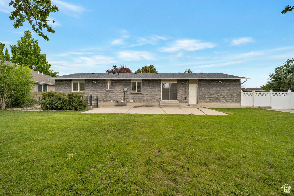 Rear view of house with a patio and brick siding