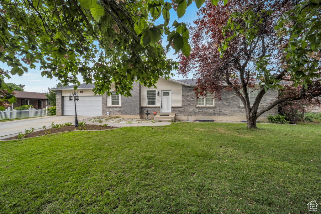 Ranch-style house featuring an attached garage, concrete driveway, and brick siding