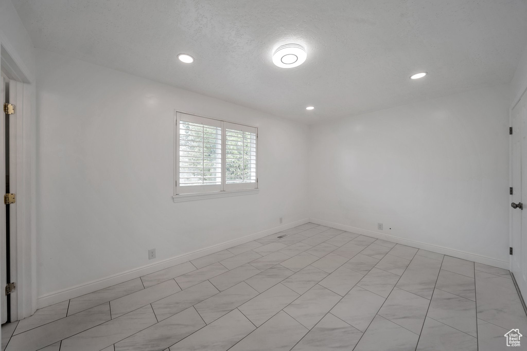 Unfurnished room featuring recessed lighting and baseboards