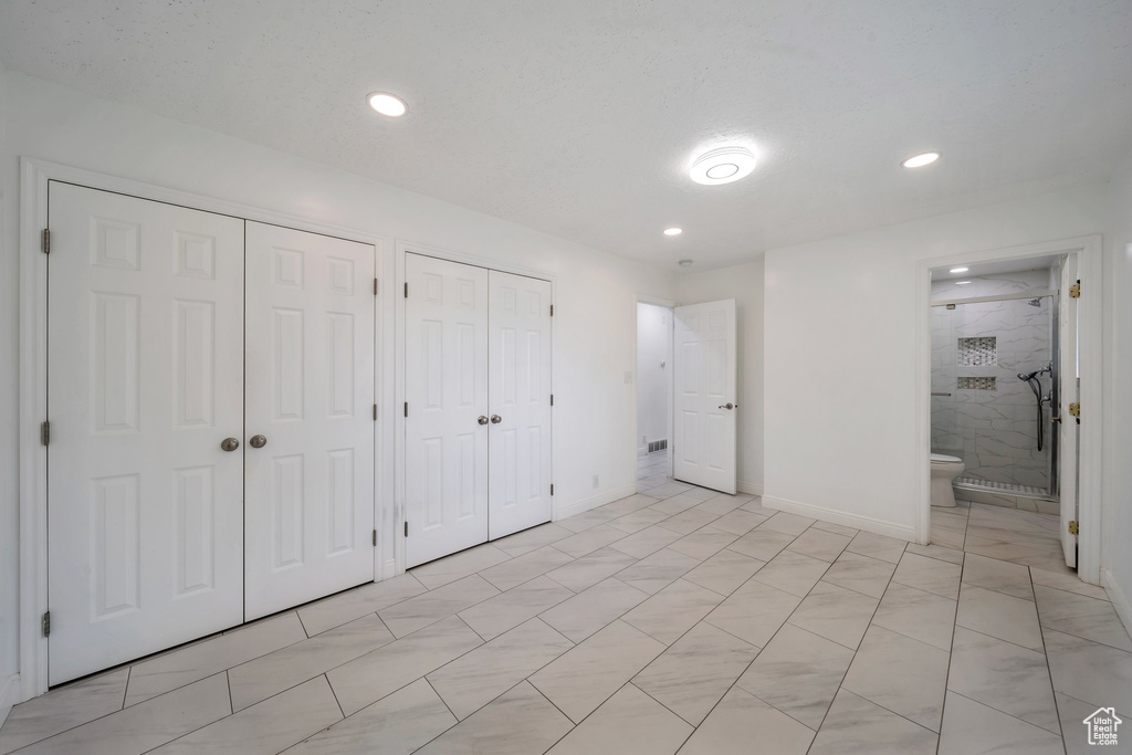 Unfurnished bedroom with multiple closets, recessed lighting, baseboards, and ensuite bathroom