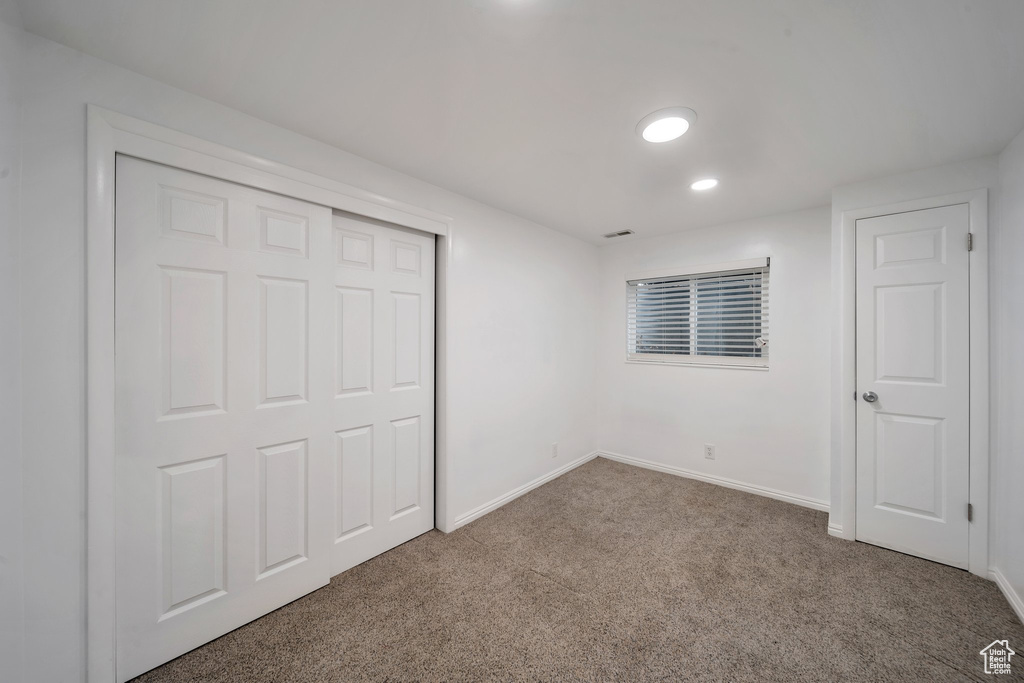Unfurnished bedroom with carpet, baseboards, a closet, and recessed lighting