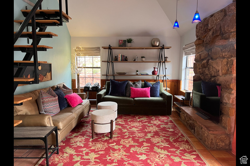 Living room featuring lofted ceiling, healthy amount of natural light, and wainscoting