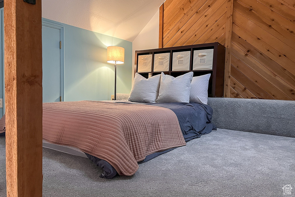 Bedroom with carpet floors and vaulted ceiling