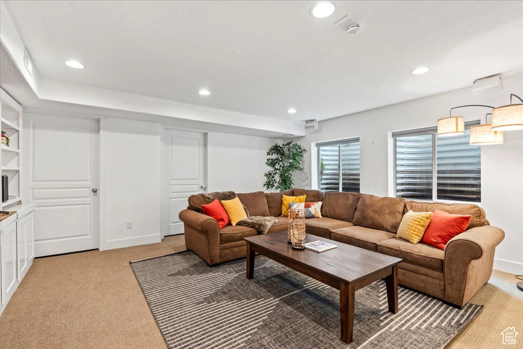Living area with light colored carpet and recessed lighting