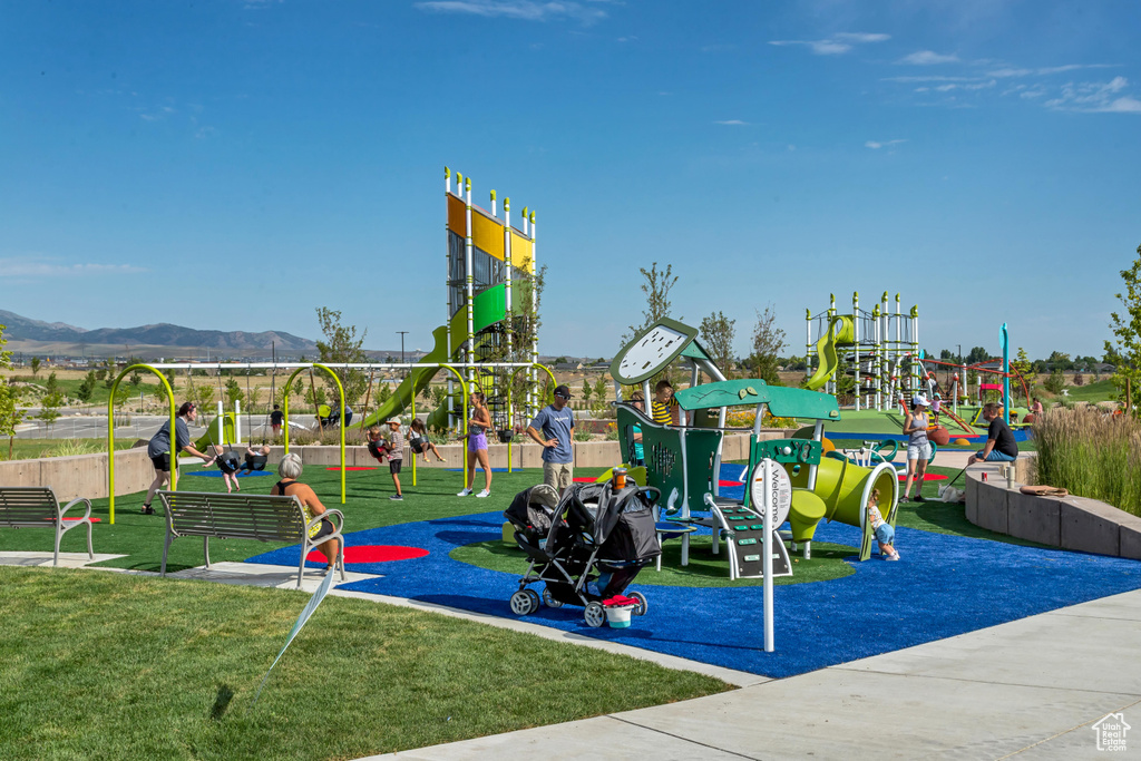 Community play area with a lawn and a mountain view