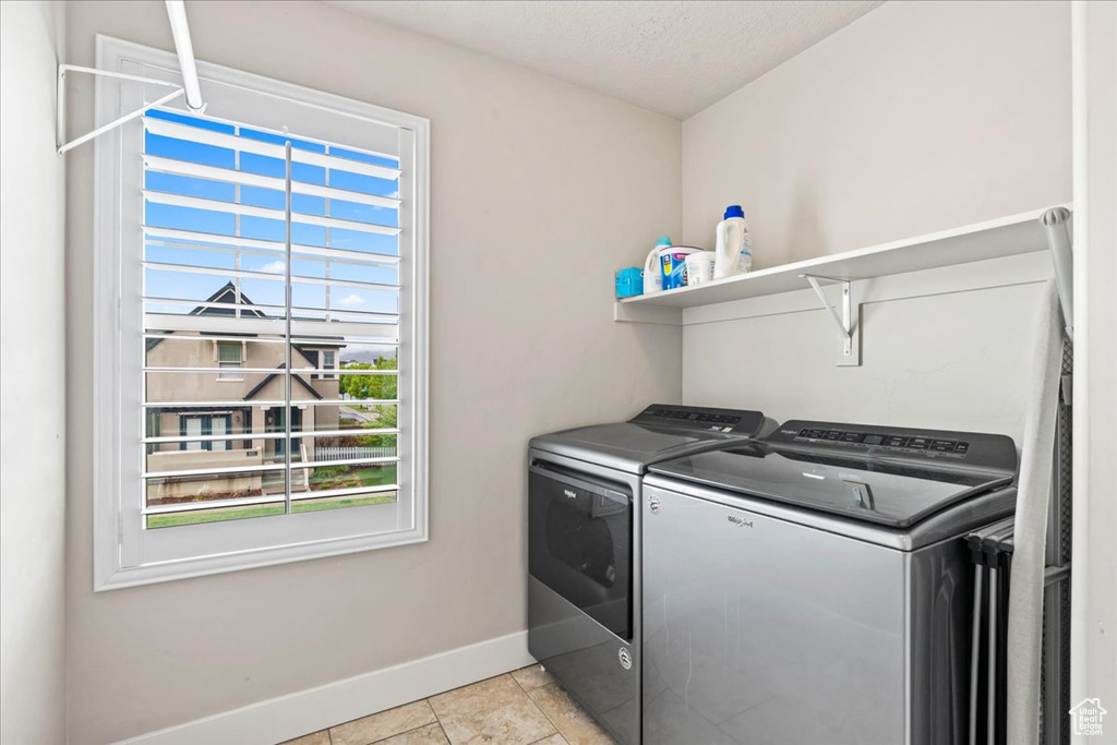 Washroom featuring baseboards, laundry area, a textured ceiling, and washer and dryer