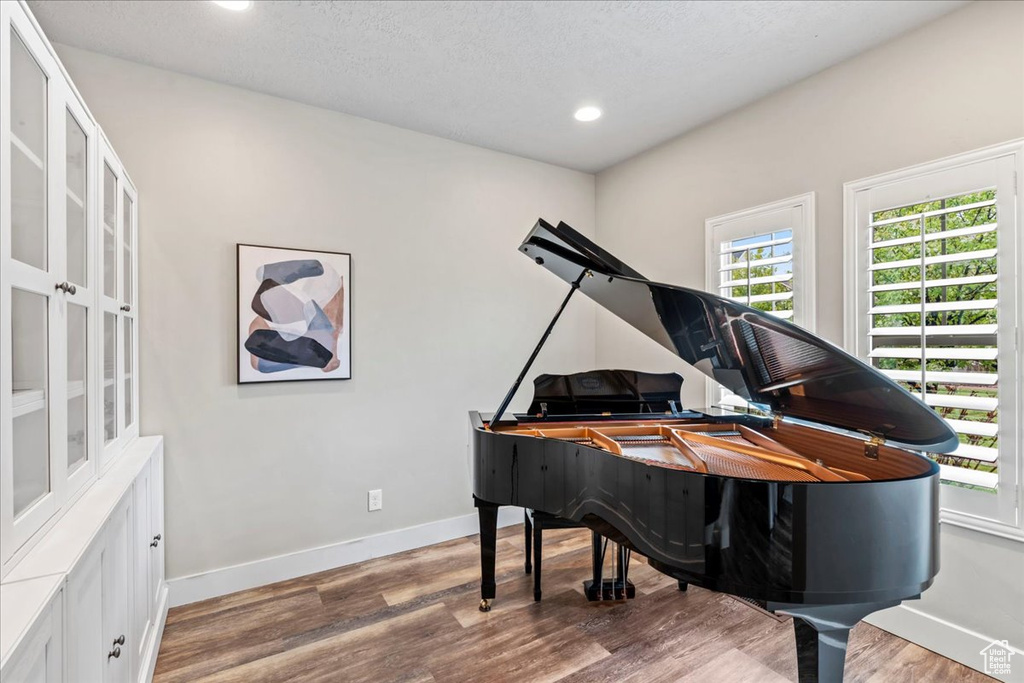 Living area with baseboards, wood finished floors, and a wealth of natural light