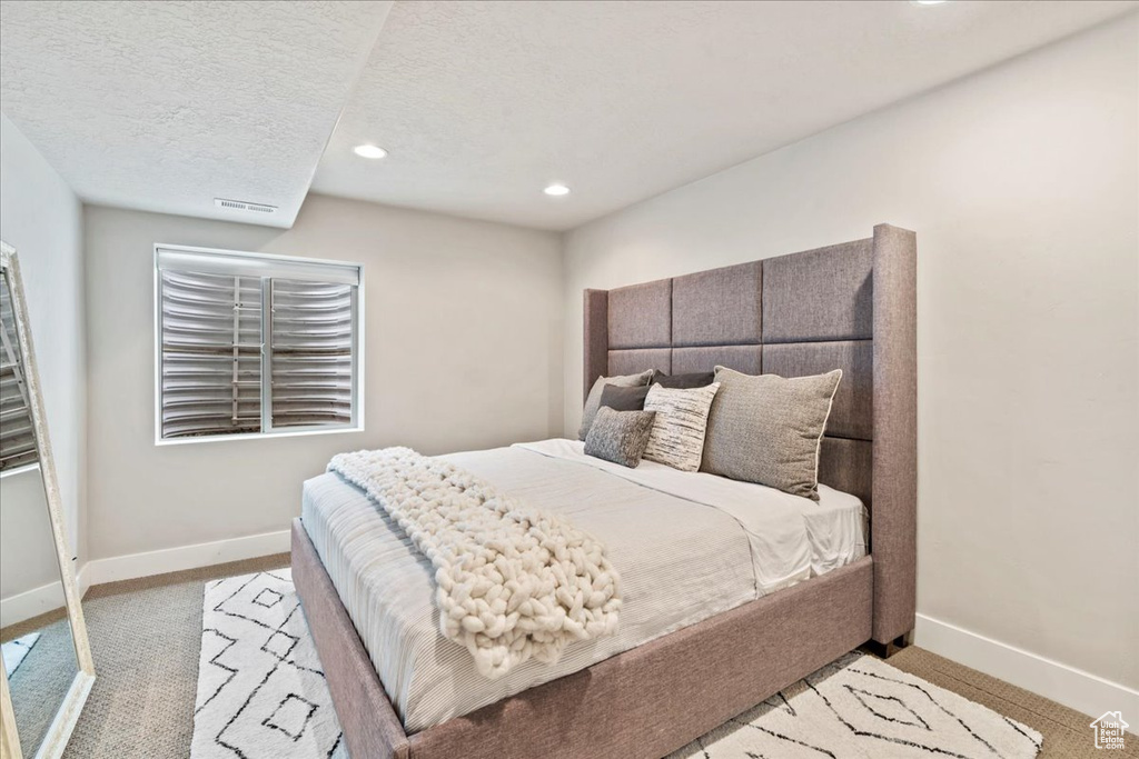 Bedroom featuring baseboards, light carpet, recessed lighting, and visible vents