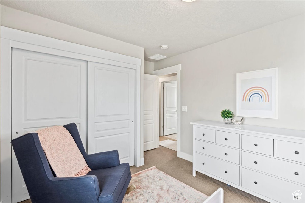 Sitting room with baseboards and light colored carpet