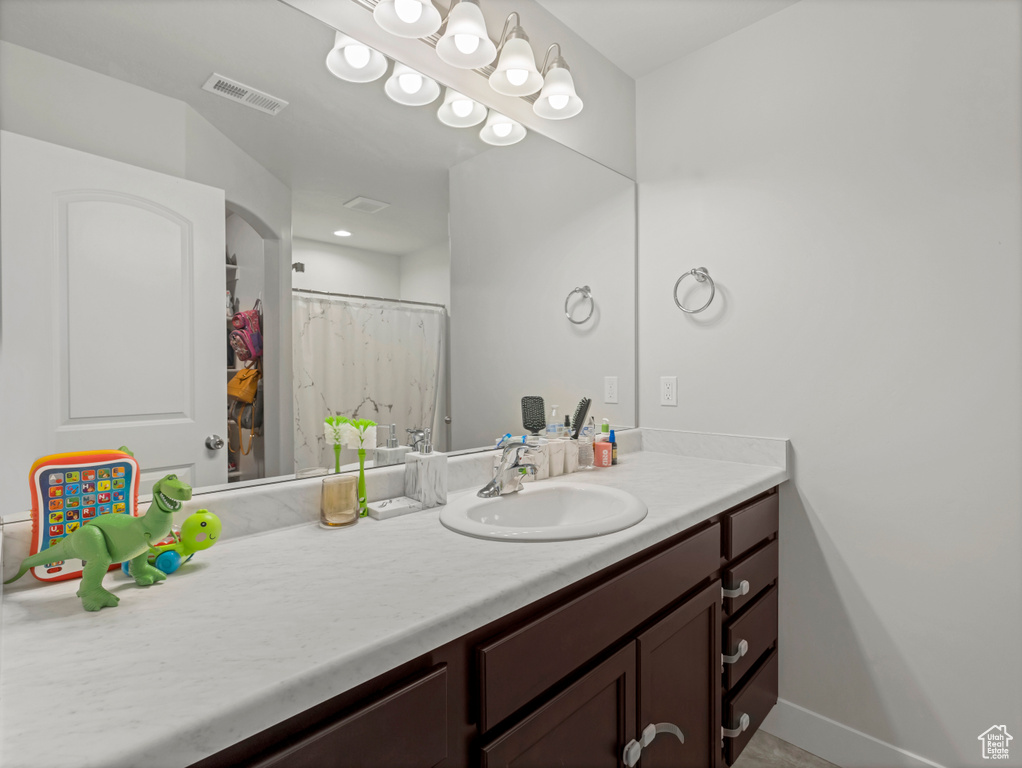 Full bathroom featuring visible vents, baseboards, and vanity