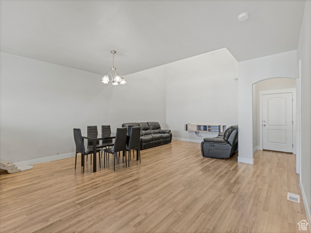 Dining space featuring baseboards, visible vents, light wood-style flooring, and a chandelier