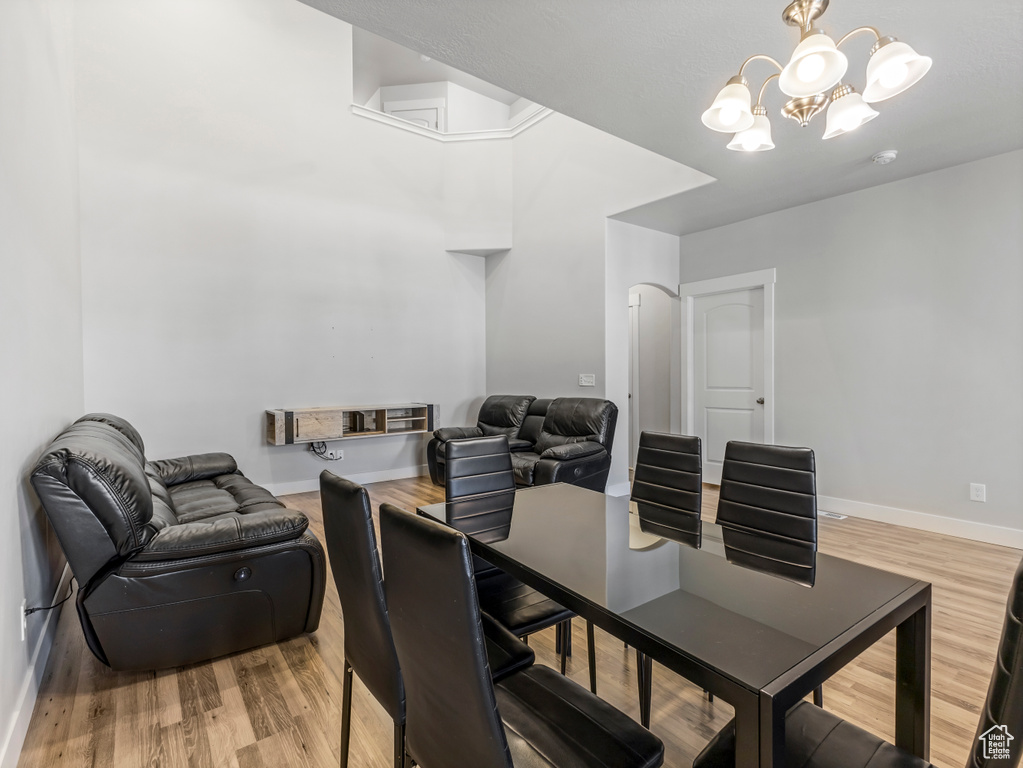 Dining area featuring baseboards, light wood-style floors, and an inviting chandelier