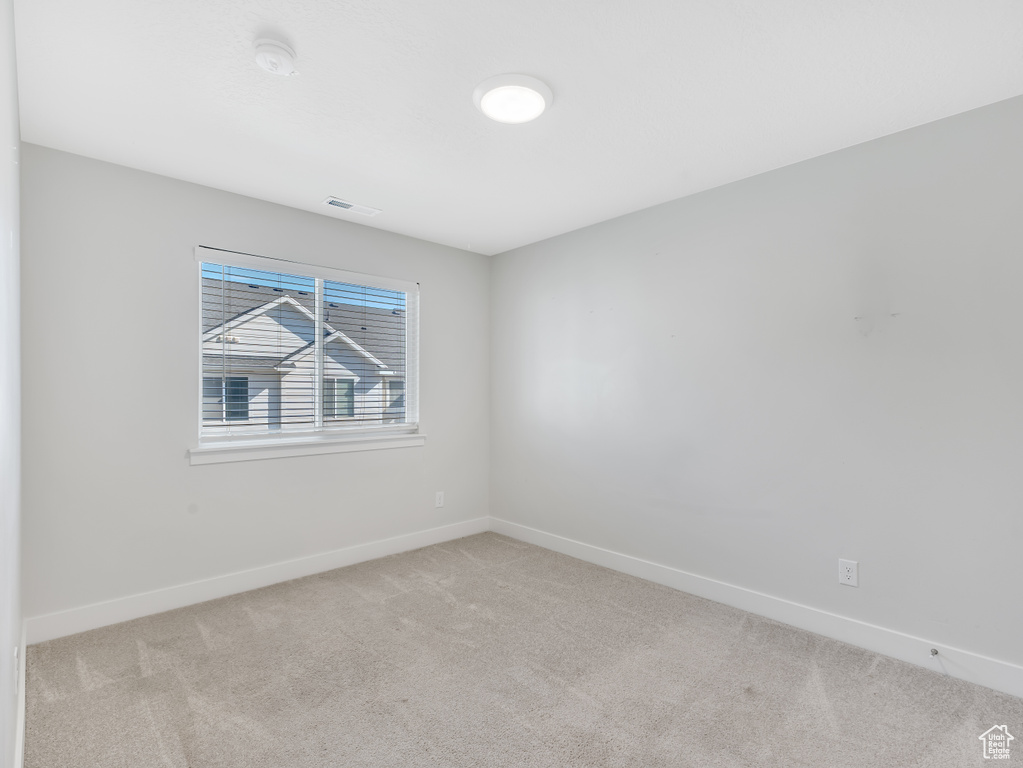 Unfurnished room with carpet, baseboards, and visible vents