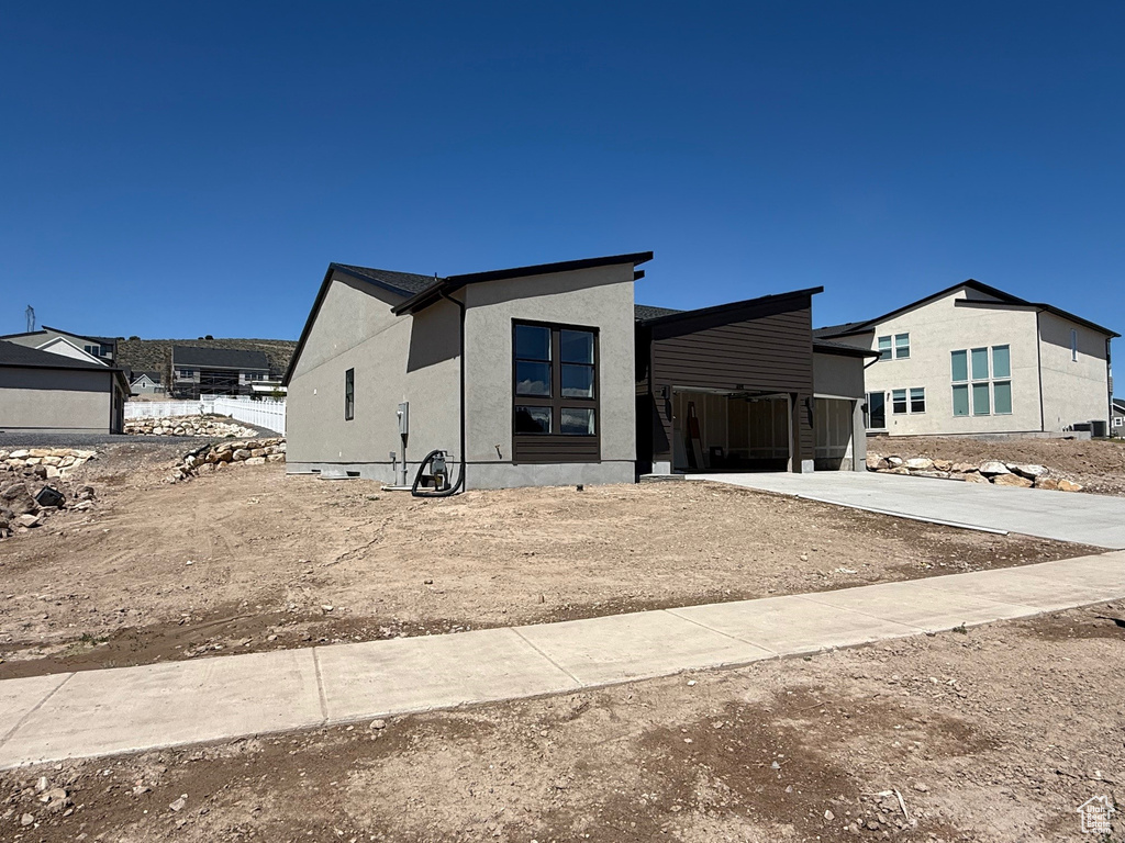 View of front of house with stucco siding and driveway