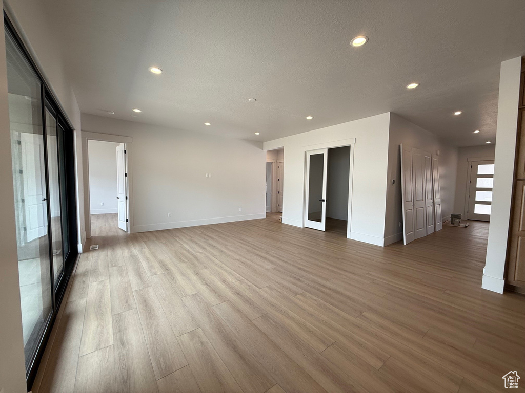 Unfurnished room featuring recessed lighting, light wood-type flooring, and baseboards