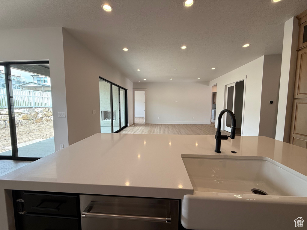 Kitchen with a sink, light wood-style floors, recessed lighting, open floor plan, and light countertops