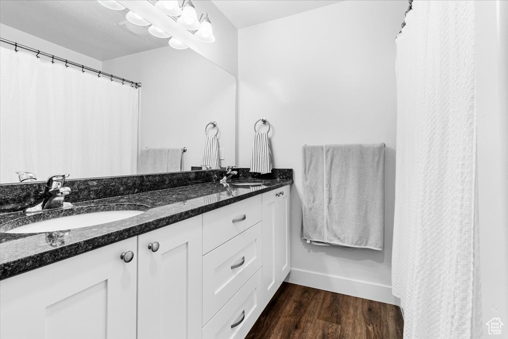 Full bath featuring wood finished floors and double vanity