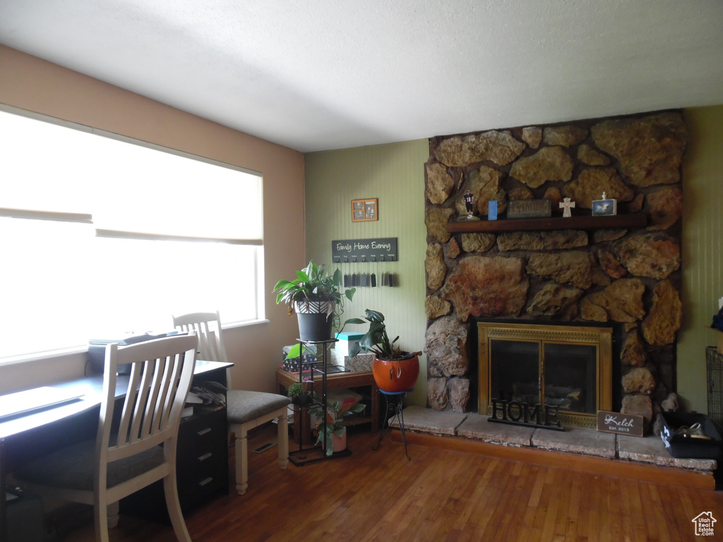Home office with wood finished floors and a fireplace