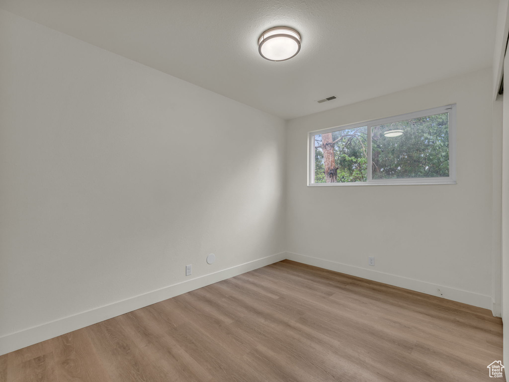 Empty room featuring light wood-type flooring and baseboards