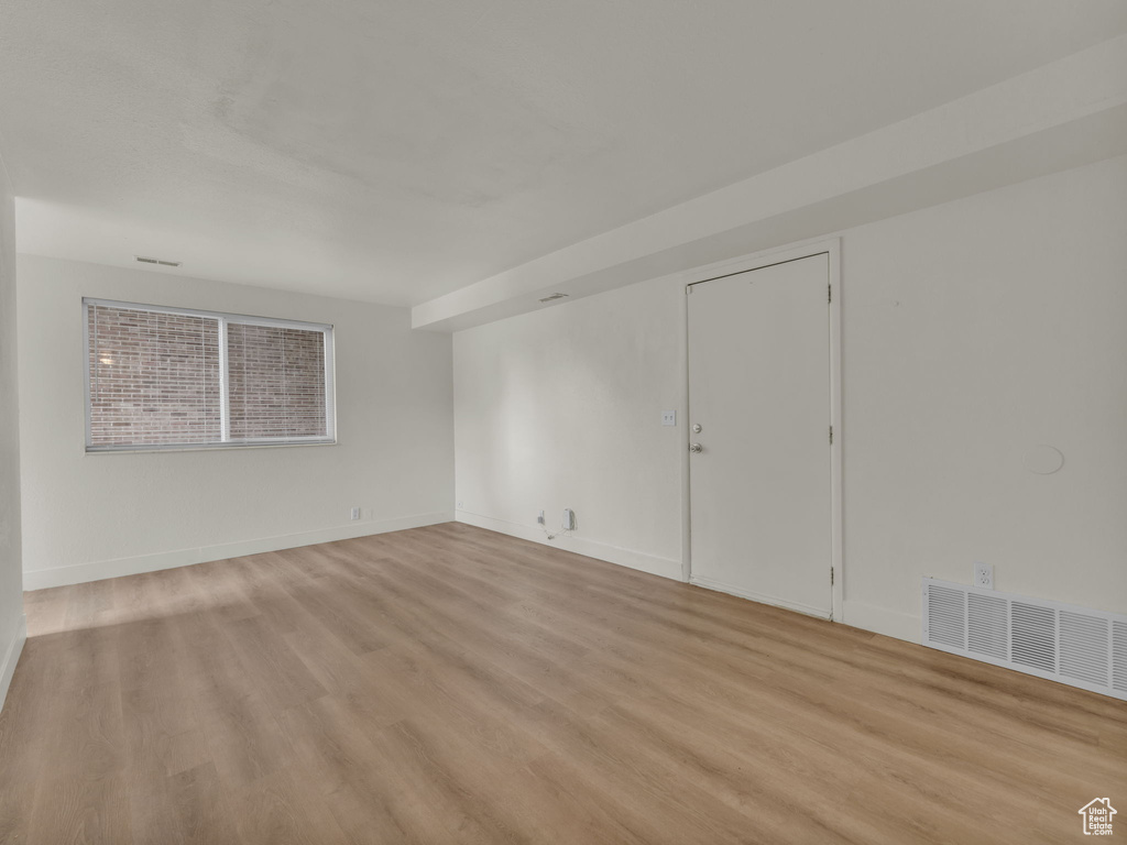 Empty room with light wood finished floors and baseboards