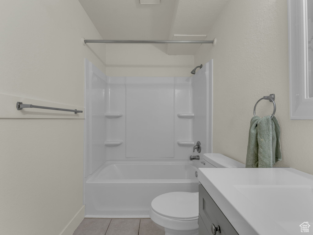 Bathroom with tile patterned flooring, toilet, vanity, baseboards, and shower / bath combination
