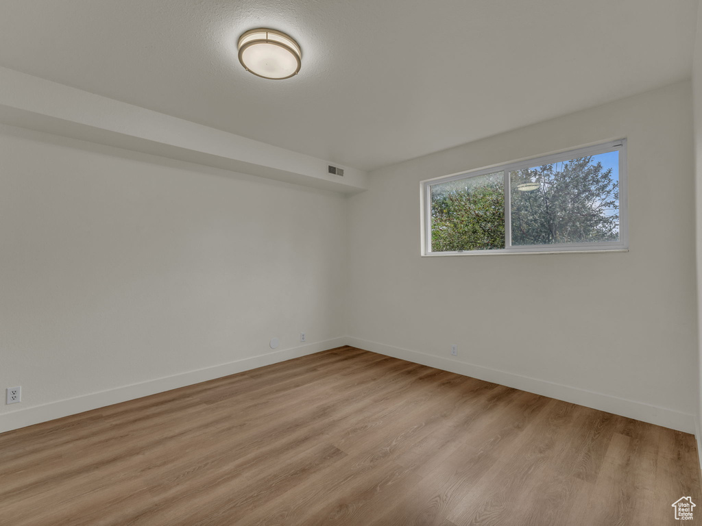 Empty room featuring baseboards and light wood-style floors