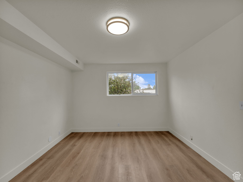 Empty room with light wood finished floors and baseboards