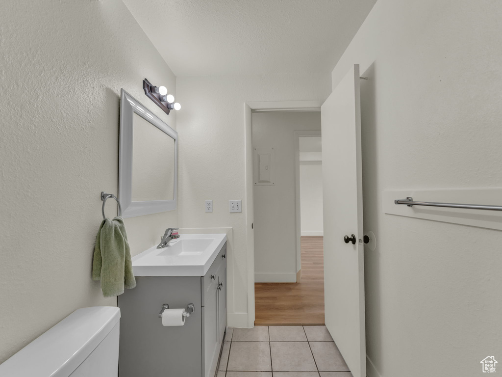 Bathroom featuring tile patterned flooring, vanity, toilet, and baseboards