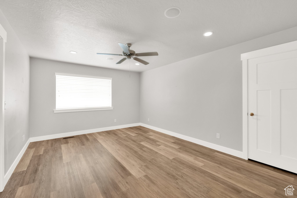 Unfurnished room with ceiling fan, wood finished floors, baseboards, and recessed lighting