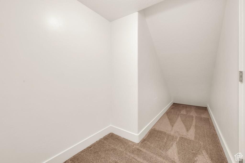 Unfurnished room featuring light carpet and baseboards