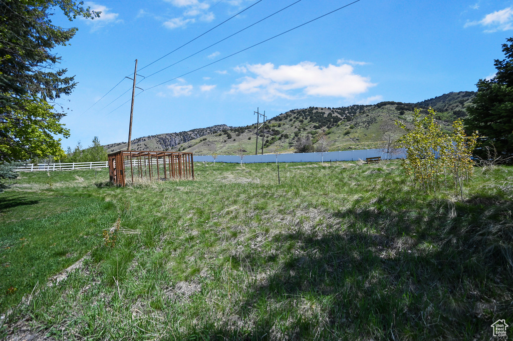 View of yard featuring a mountain view, a rural view, and fence
