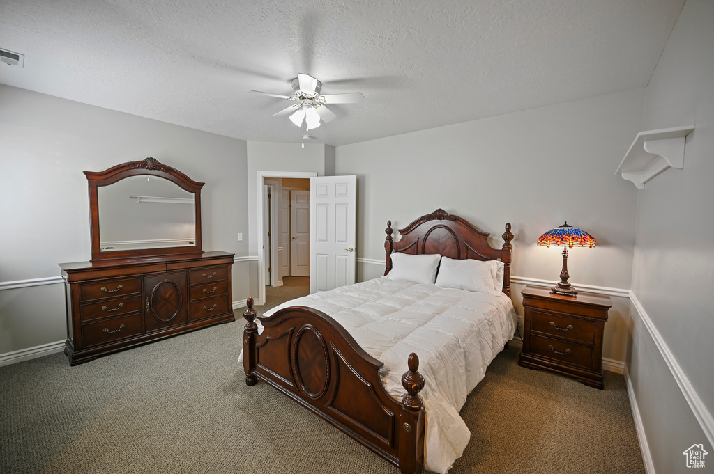 Carpeted bedroom featuring baseboards, visible vents, ceiling fan, and a textured ceiling