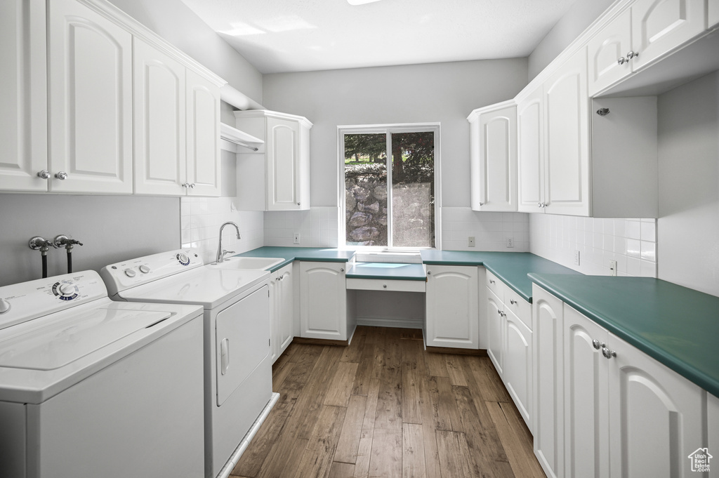 Laundry area featuring a sink, cabinet space, independent washer and dryer, and dark wood finished floors
