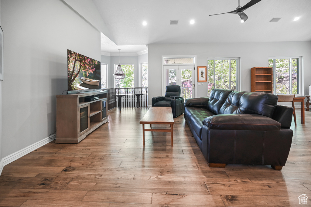Living room with a ceiling fan, hardwood / wood-style floors, visible vents, ornamental molding, and recessed lighting